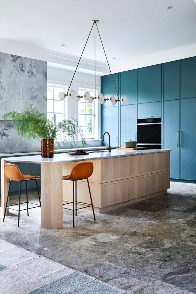 A Dutch-inspired kitchen with a quartzite island and turquoise cabinets.