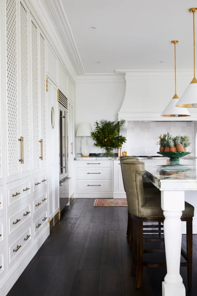 A white luxury kitchen with gold accent fixtures.