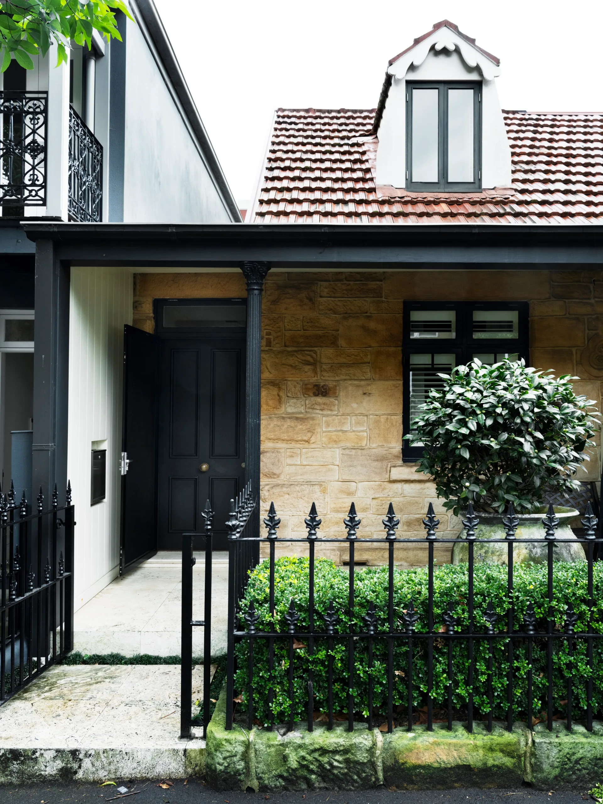 The front facade of an 1800s sandstone cottage.