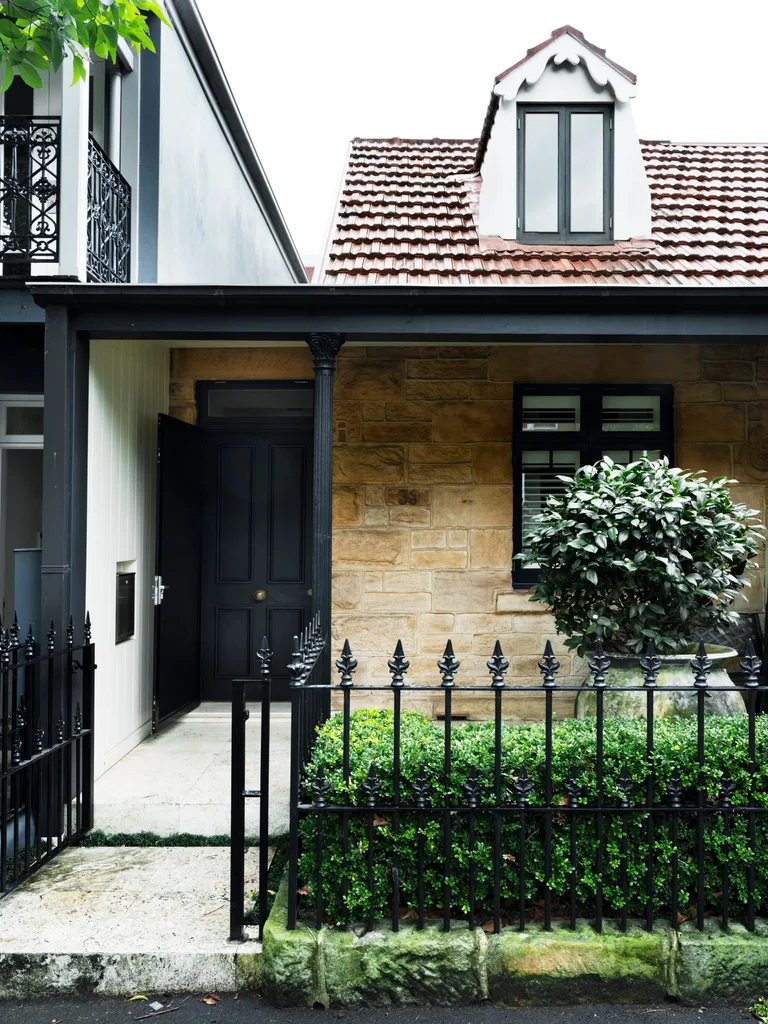 The front facade of an 1800s sandstone cottage.