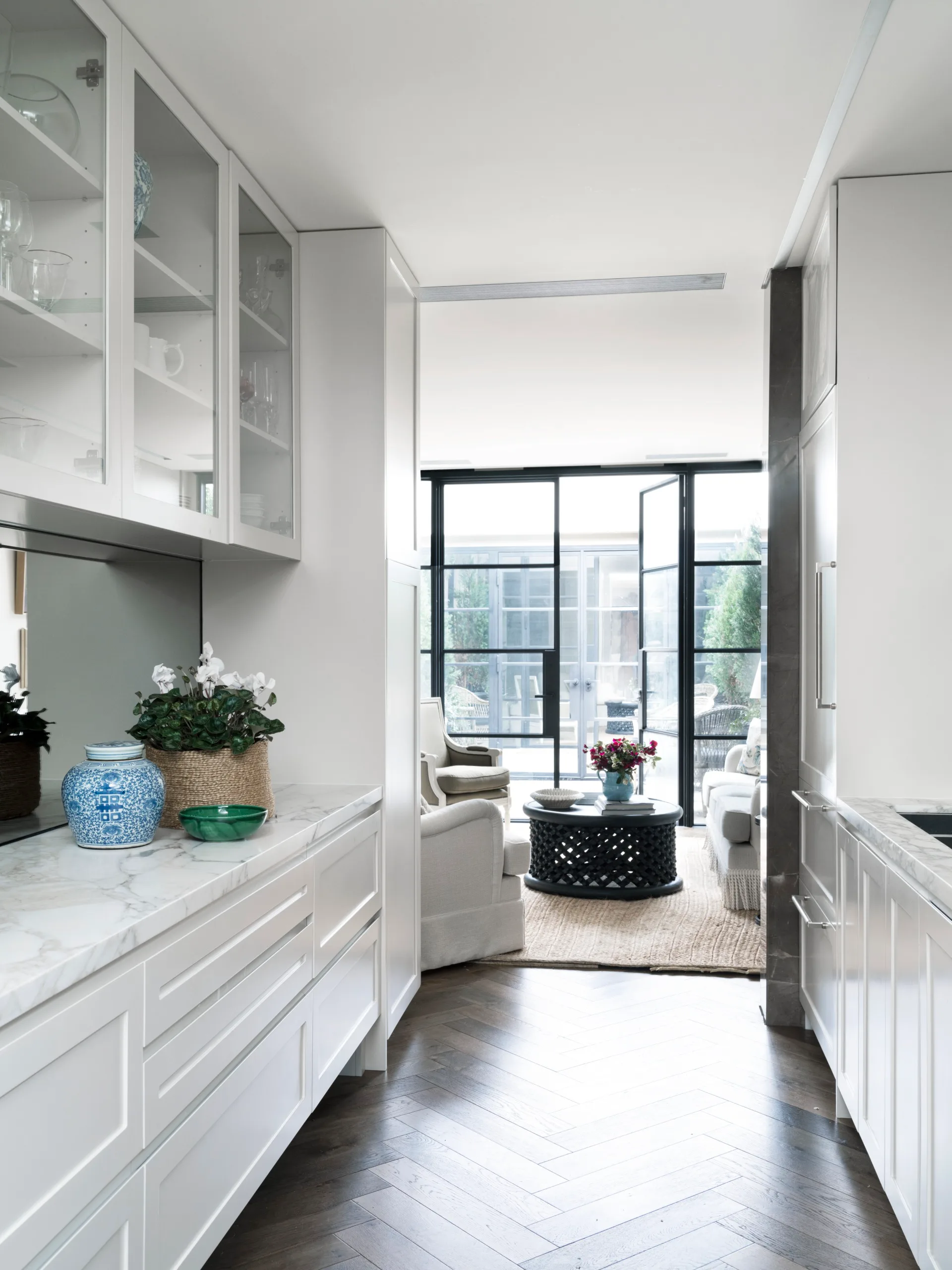 A long classic style kitchen with marble benchtops.