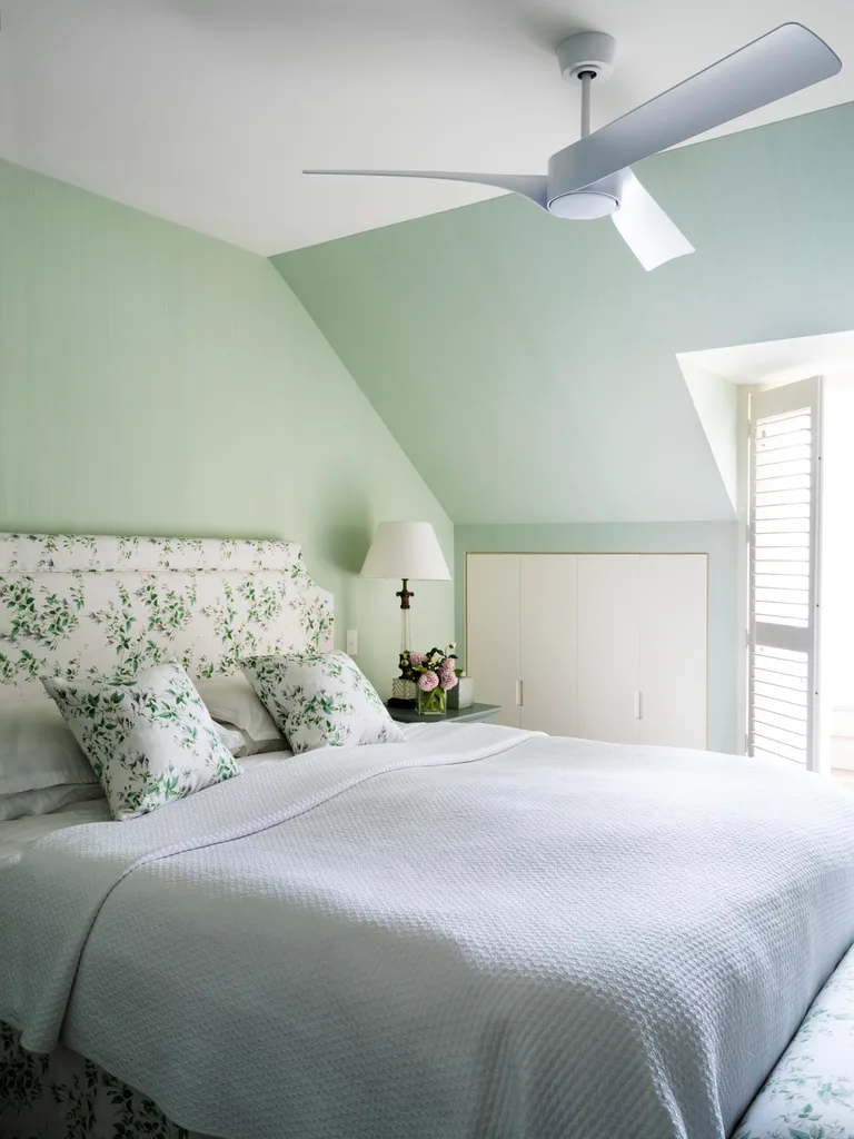 A classic style main bedroom in pastel green with floral accents.