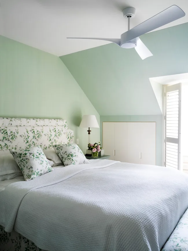 A classic style main bedroom in pastel green with floral accents.
