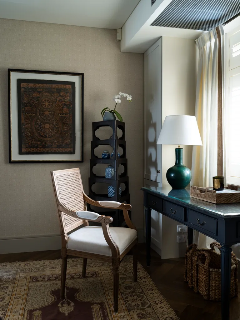 A study with vintage furniture and a Nepalese framed artwork.