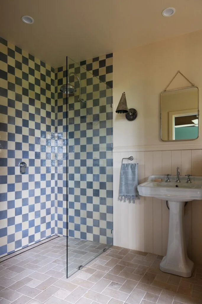 A guest ensuite with a blue checked shower and VJ panelling.