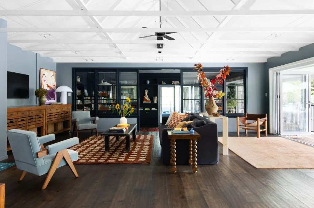 An eclectic living area with a raised open ceiling and vintage style furniture.