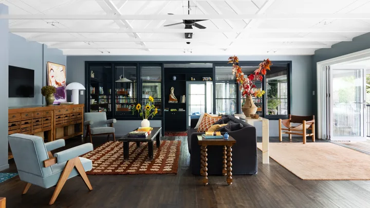 An eclectic living area with a raised open ceiling and vintage style furniture.