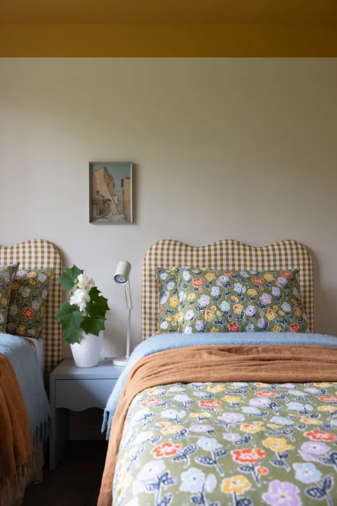 Twin beds with a checked bedhead and floral linen.