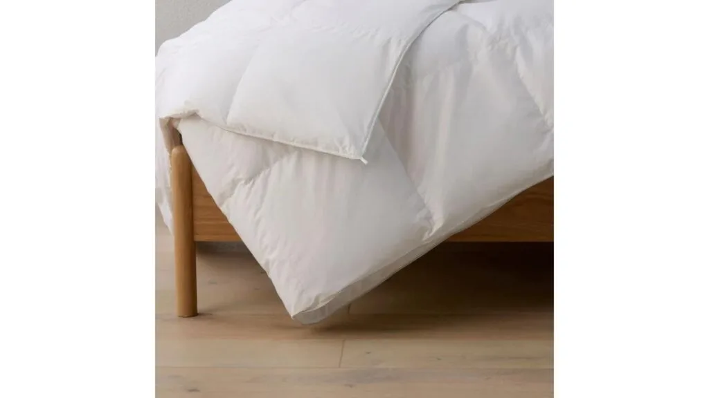 A duck-down duvet draped over a bed.