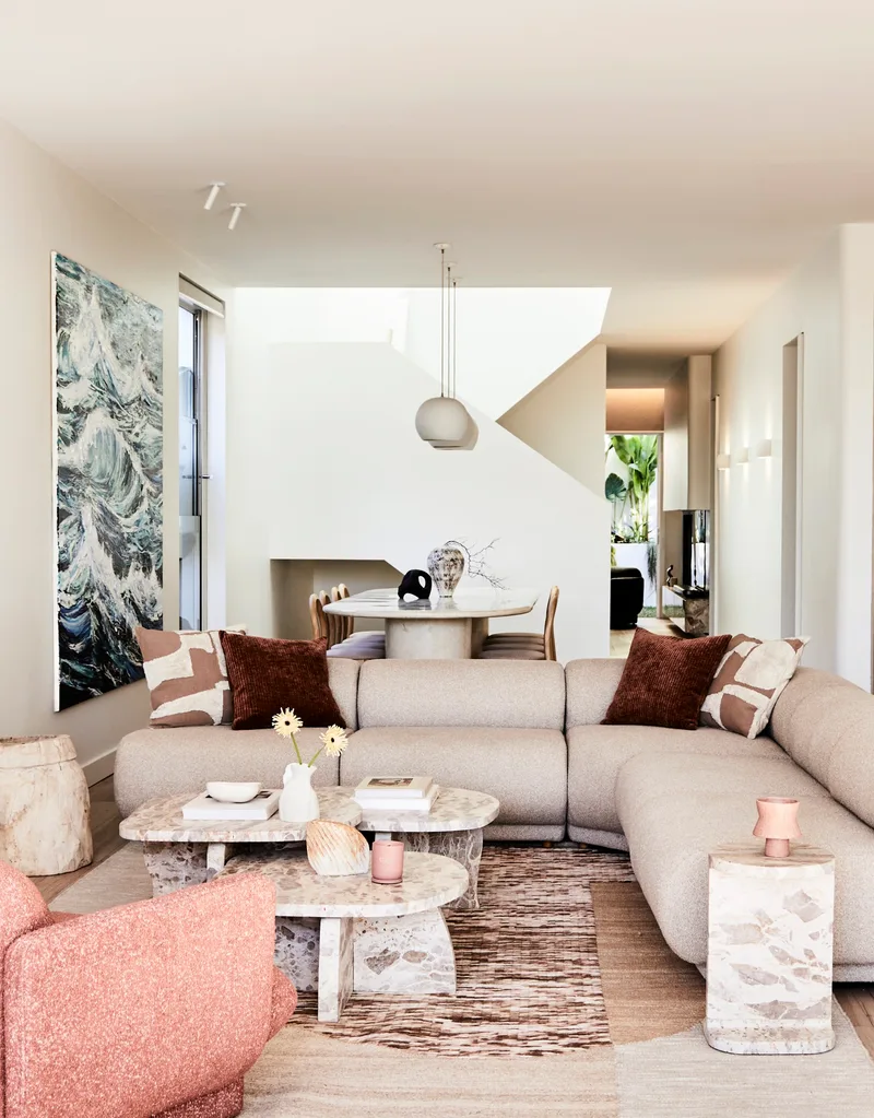 Darren Palmer's Bondi home living room with cream couch and pink armchair.