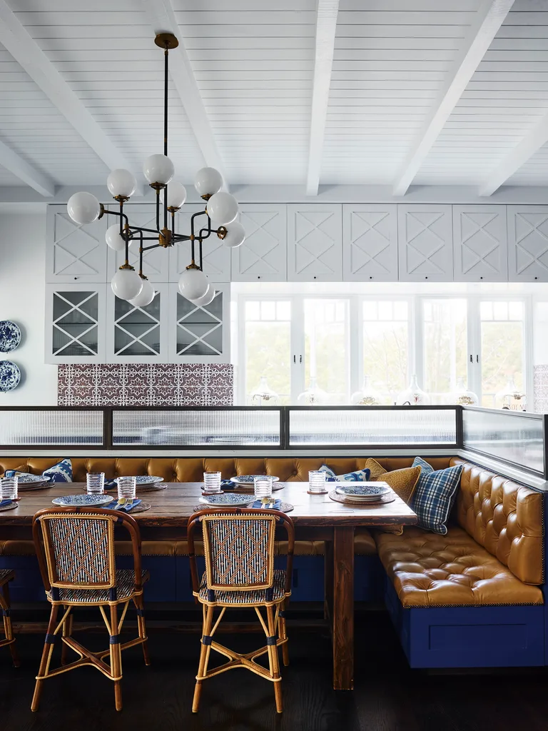 Eldelman leather on the banquette seating, plus bistro chairs, make for a stylish breakfast nook, complete with touches of blue in the cushions and tableware.