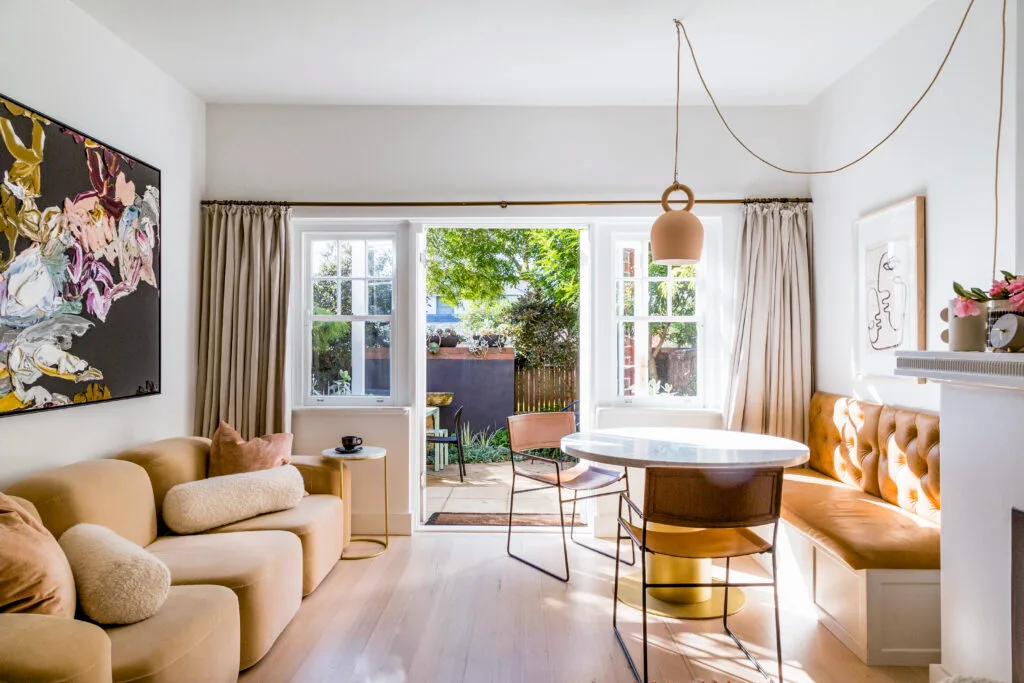 Caramel tones feature heavily in this open plan living area and breakfast nook, complete with leather banquette seating and a brass base on the circular dining table.