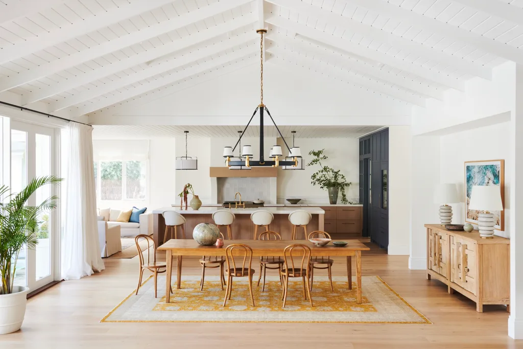 A spacious kitchen and dining room with raised ceilings and timber furniture.