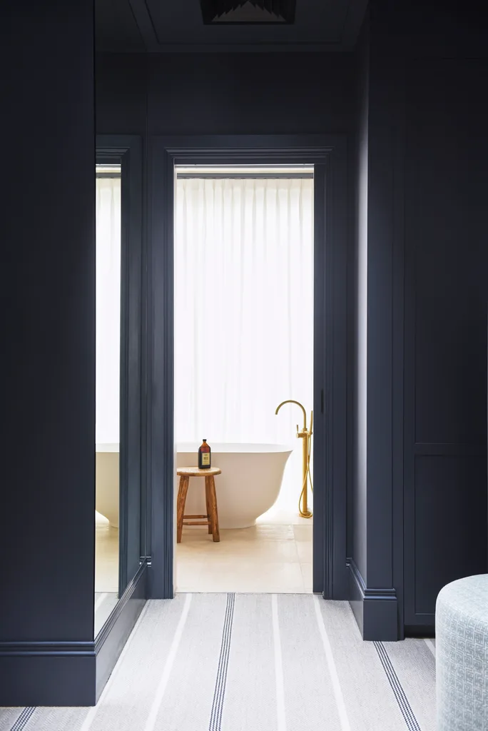 A navy walk-in robe leading to an ensuite.