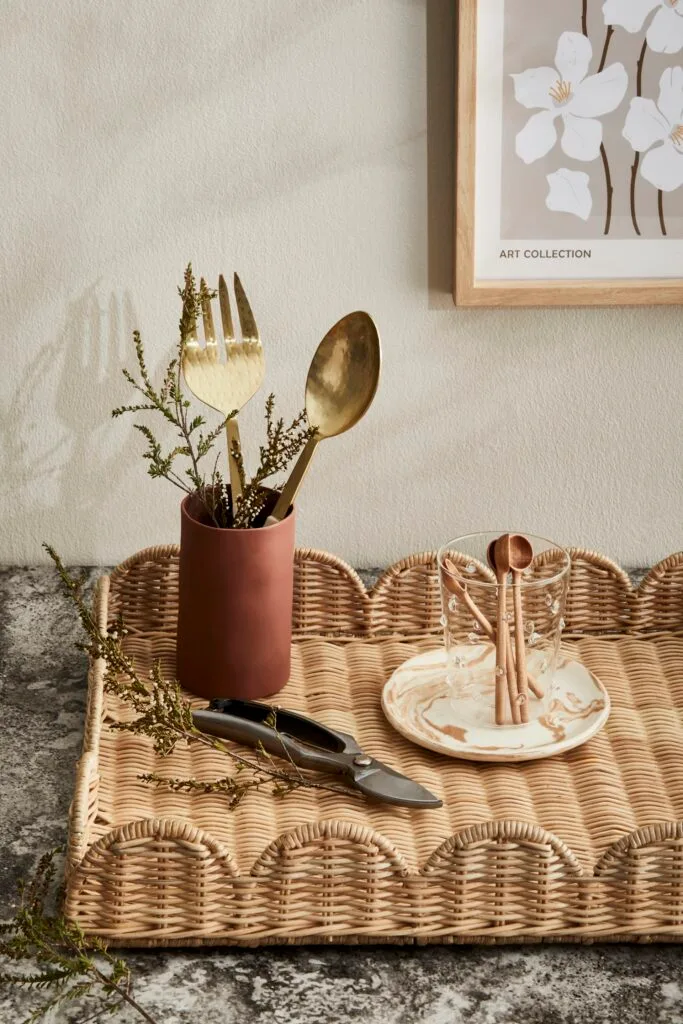 A scalloped rattan tray holding serving items.