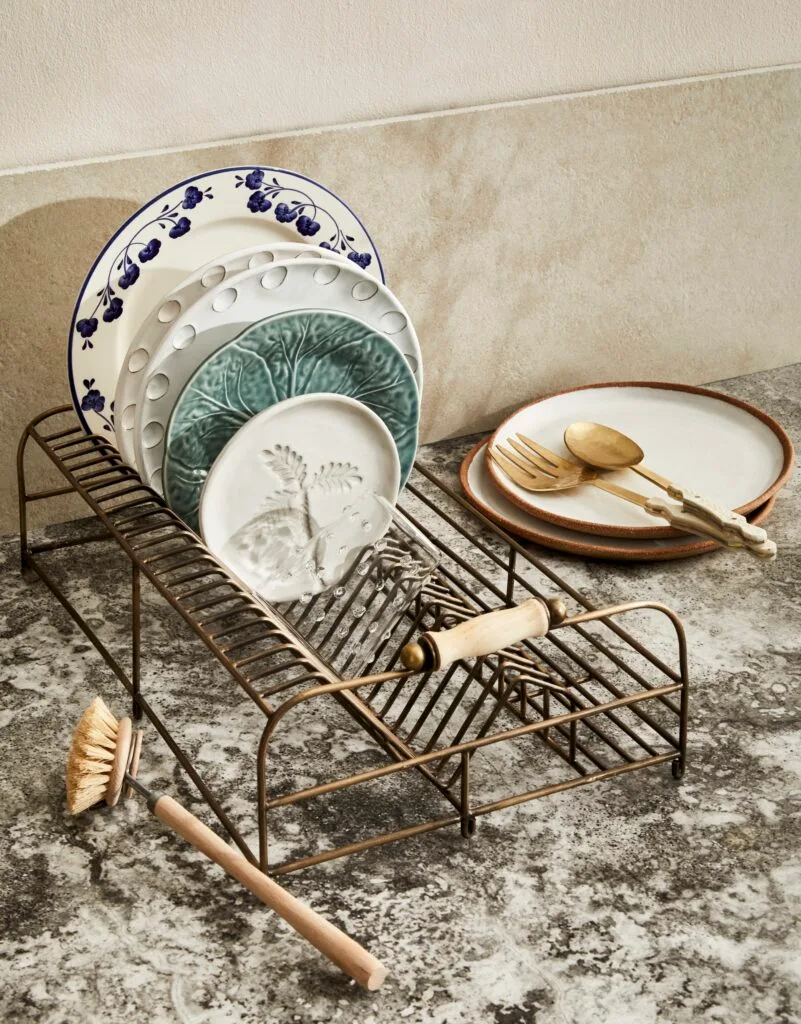 An antique-style dish rack holding a collection of ceramic plates.