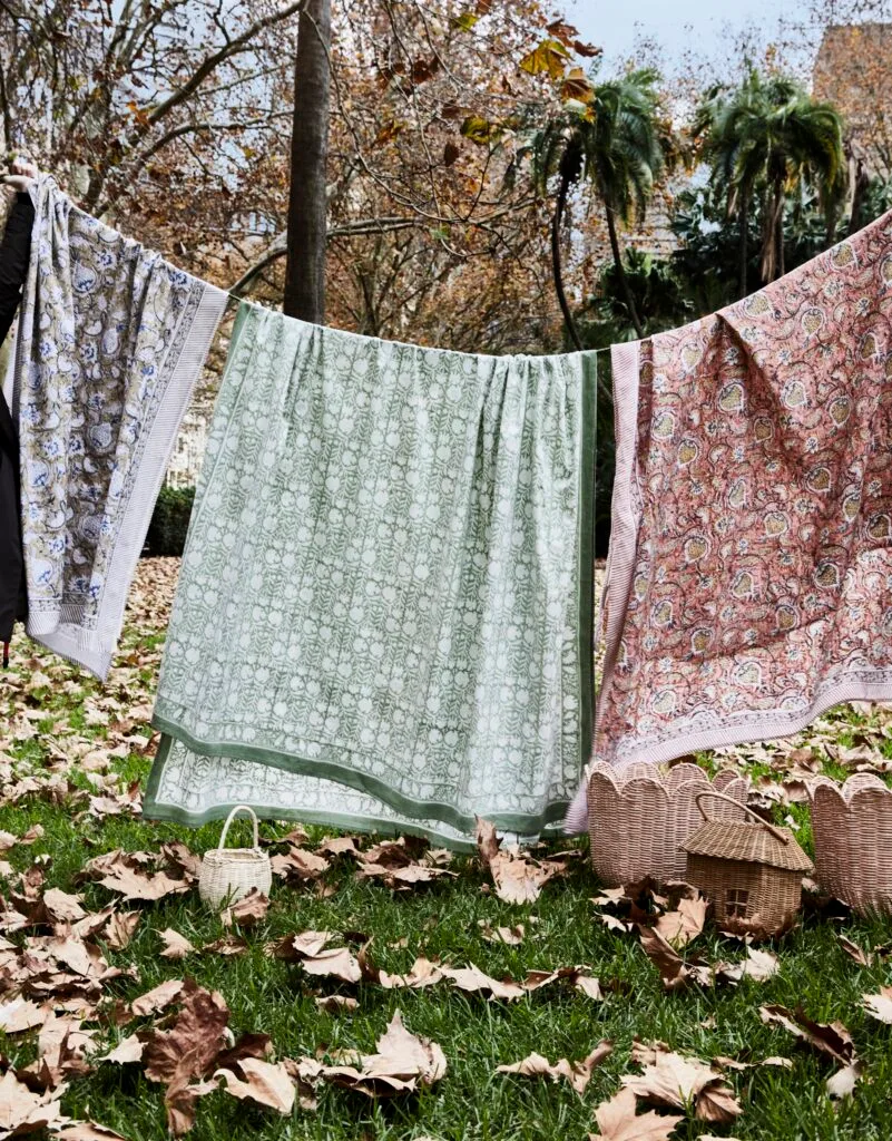 Three sets of patterned table cloths on a washing line.