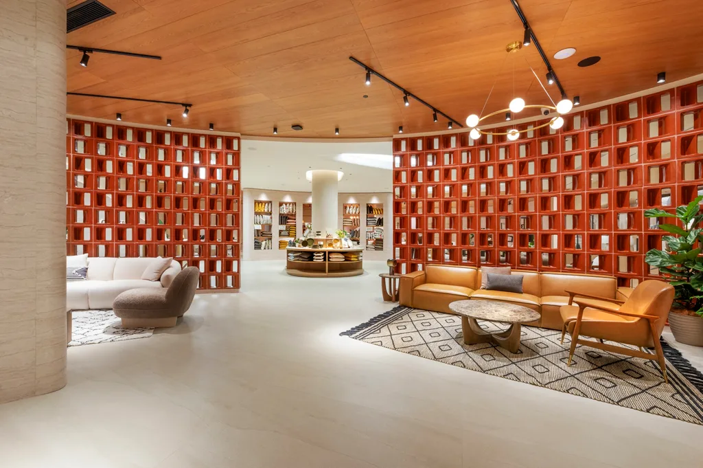 A furniture showroom with red floor-to-ceiling shelves and tan leather and white sofas.