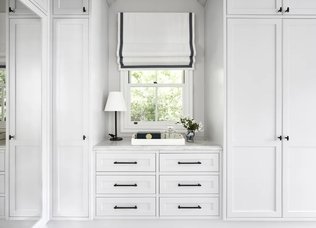 An all-white dressing room with country-style cabinets and drawers.
