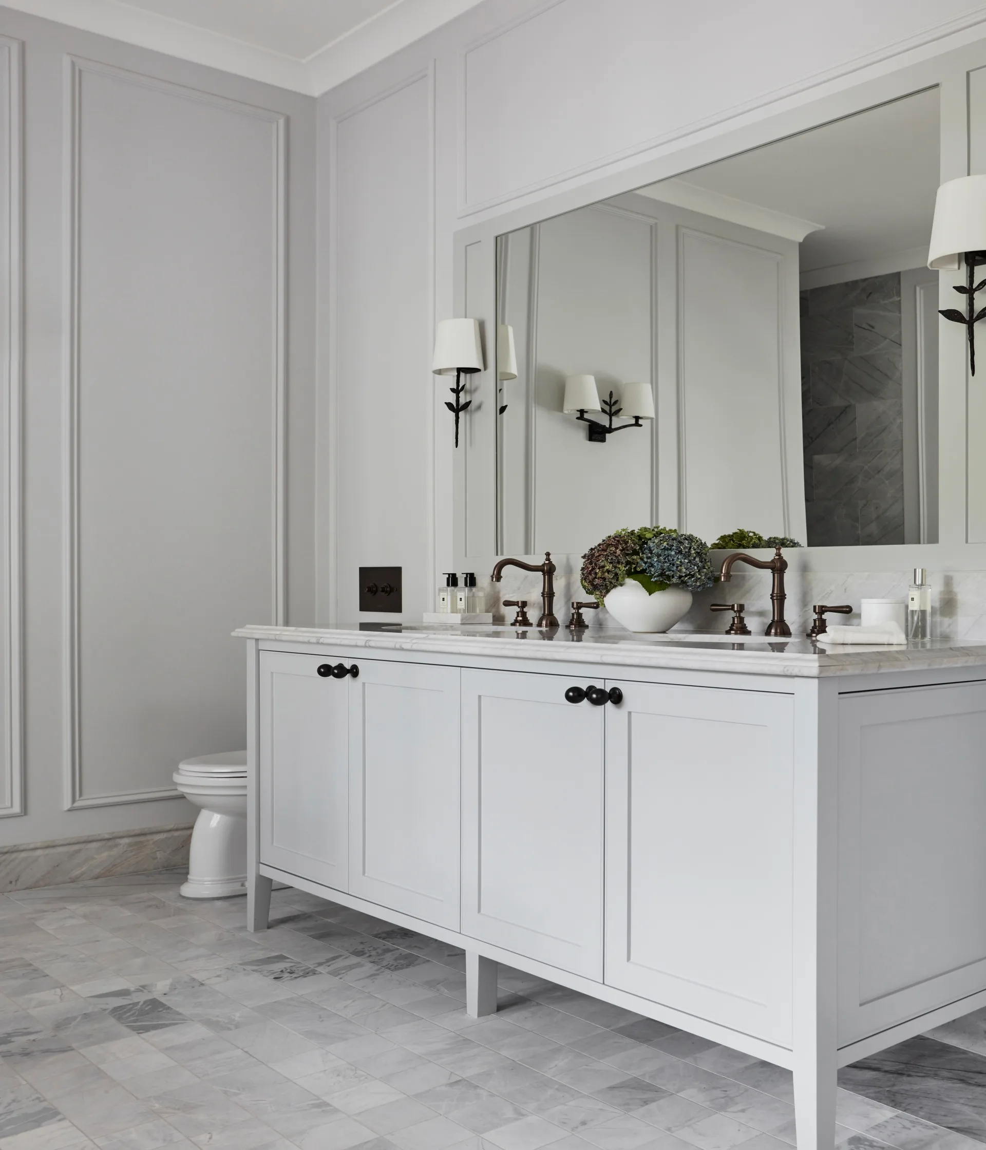 A country-style ensuite with a double vanity and wall wainscoting.