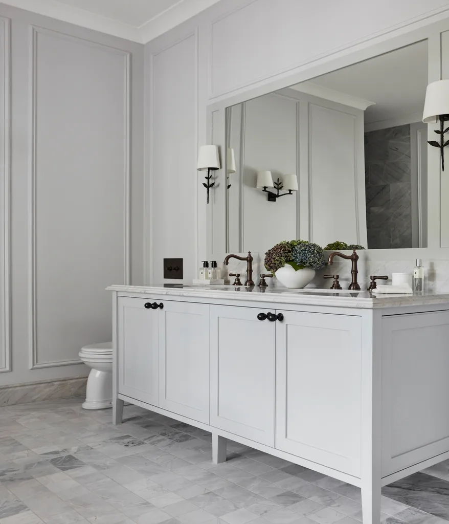 A country-style ensuite with a double vanity and wall wainscoting.