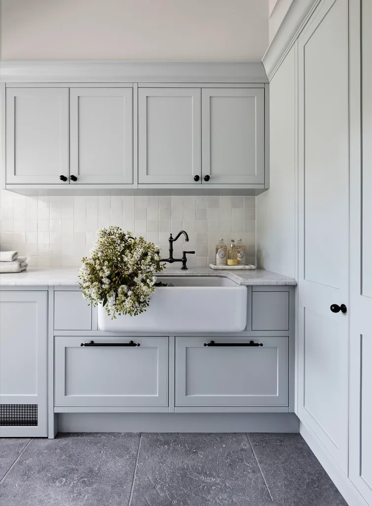 A classic grey country laundry with a farmhouse sink and shaker cabinets.