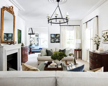 A country-style living room with a marble fireplace, vintage mirror and furniture.