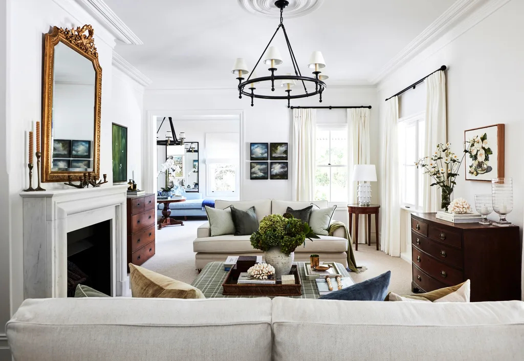 A country-style living room with a marble fireplace, vintage mirror and furniture.