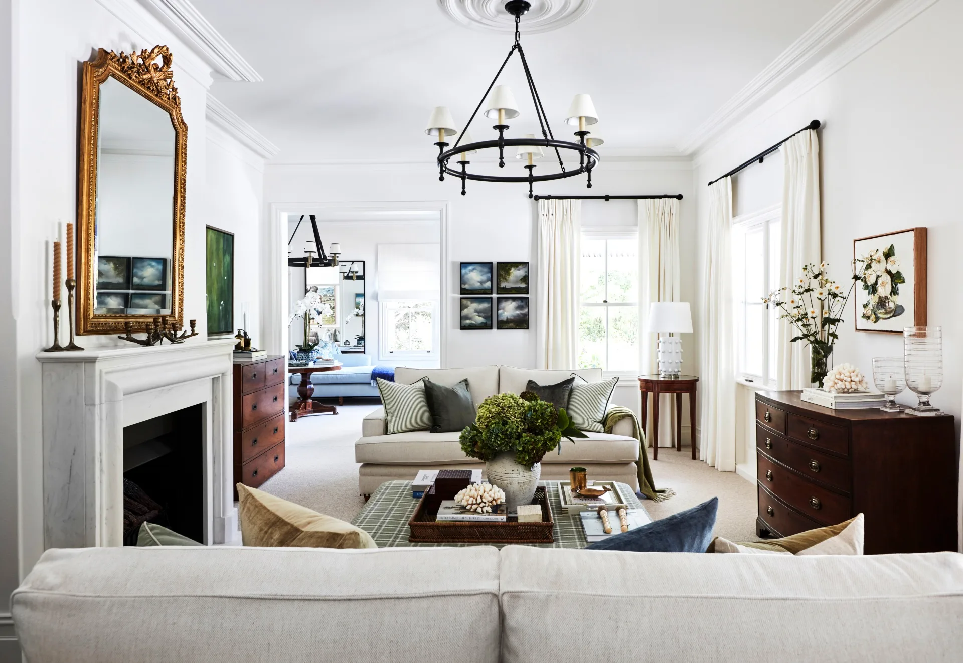 A country-style living room with a marble fireplace, vintage mirror and furniture.