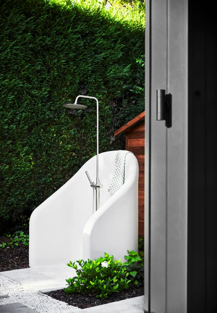 An outdoor shower with a curved partition wall.