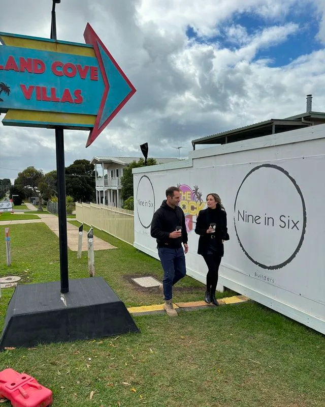 Dan and Dani from The Block walking next to the Island Cove Villas Sign.