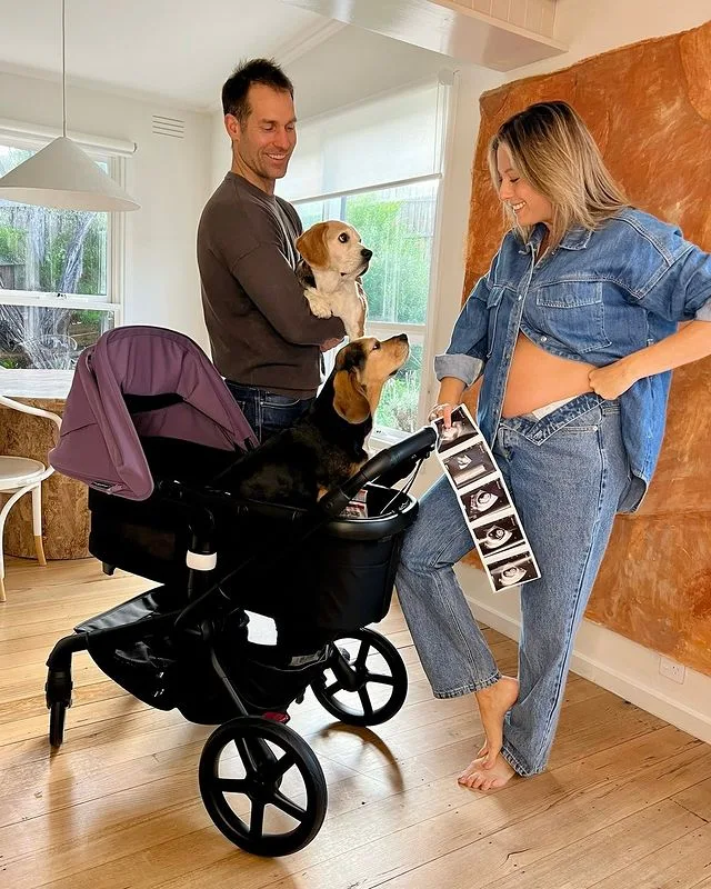 Dan and Dani from The Block showing Dani's bump with two dogs.