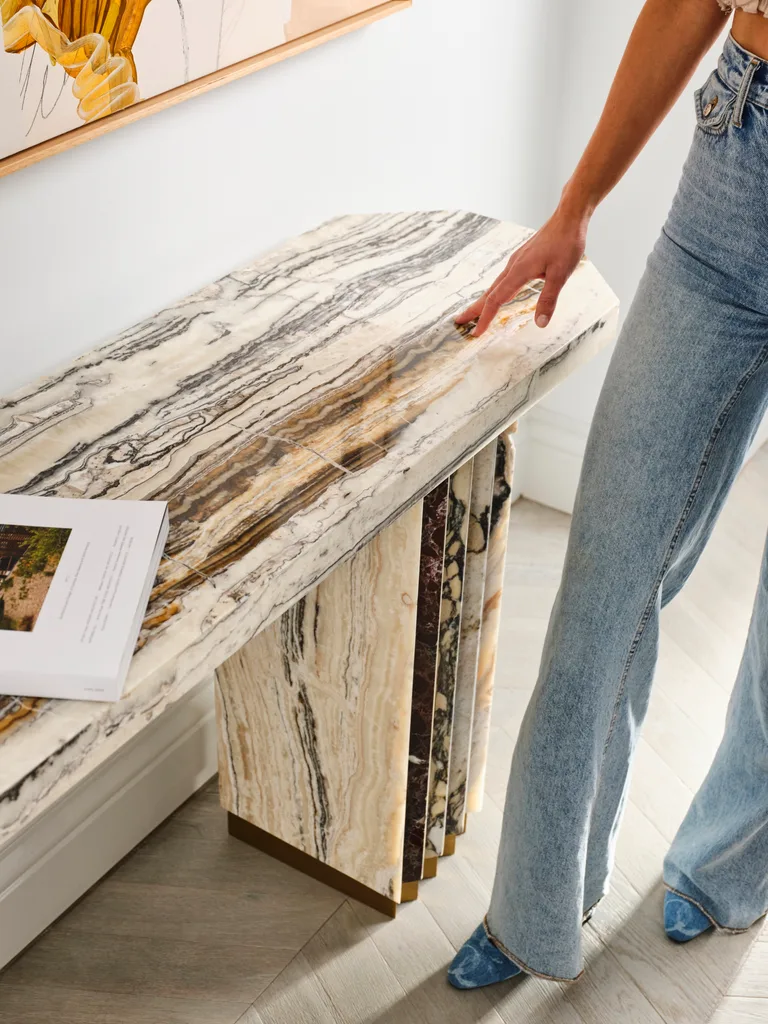 Marble console table with a coffee table book on top.