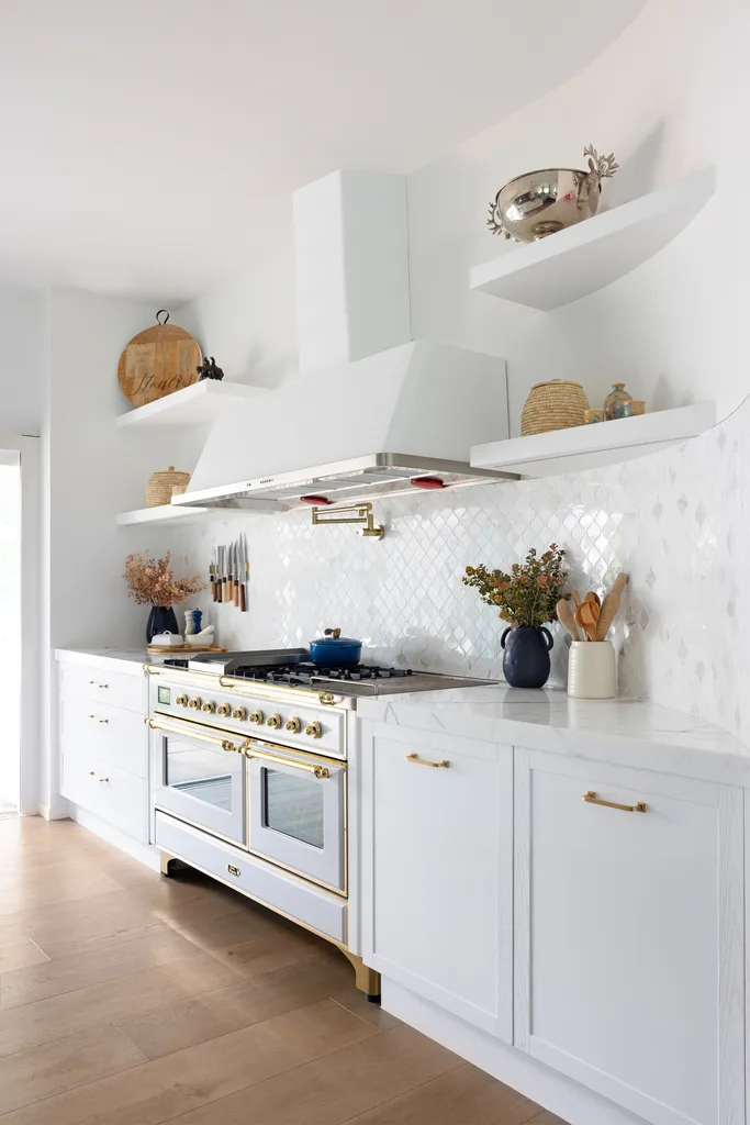 A modern country kitchen with white shaker cabinets and a gloss tiled splashback.