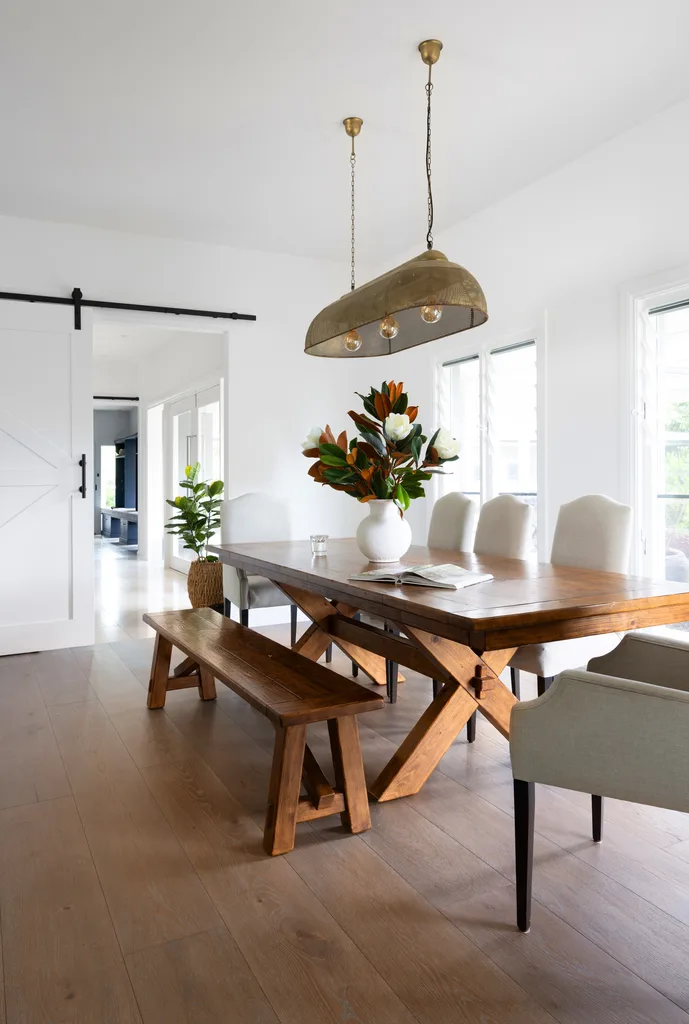 A dining room with a large timber table and sliding farmhouse door.