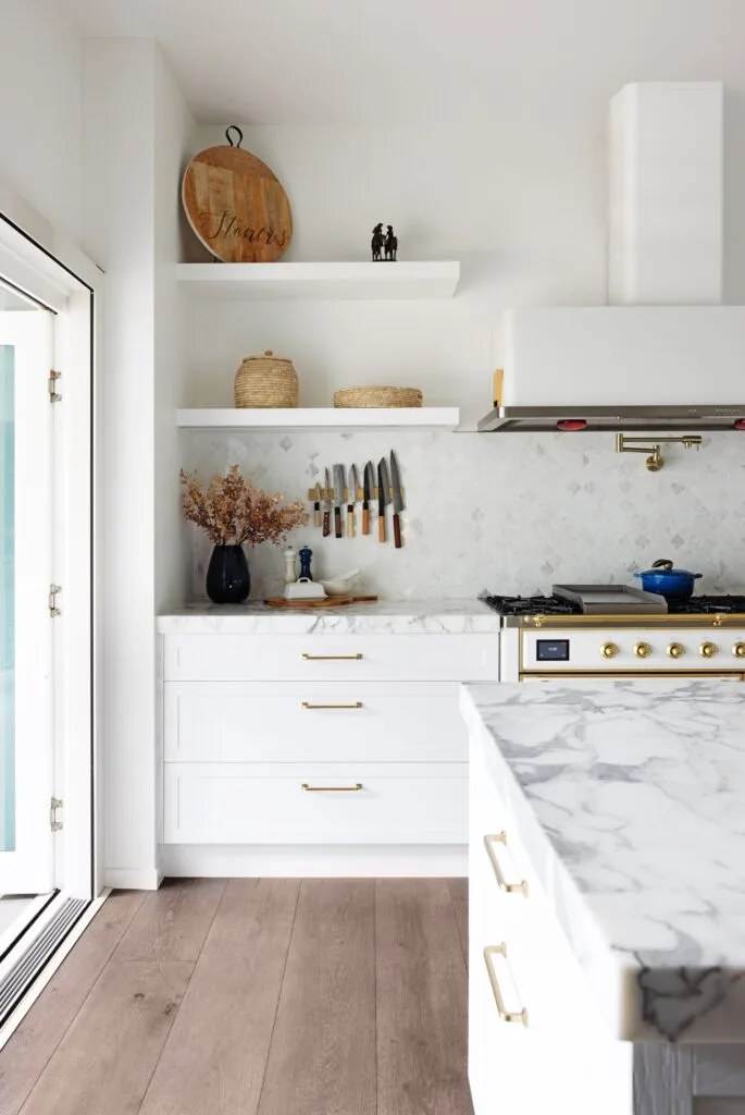 White shaker kitchen cabinets with gold handles.