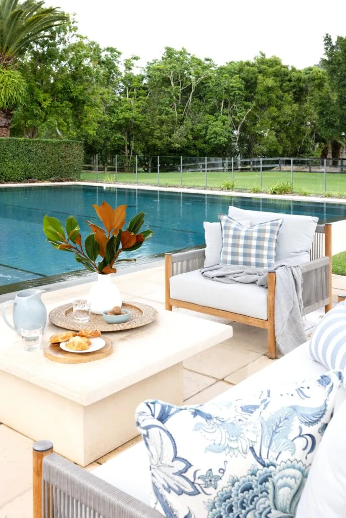 An outdoor area with white chairs beside a pool.