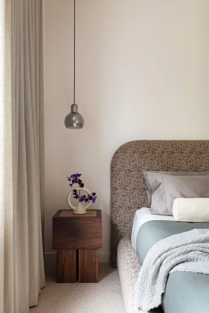 A main bedroom decorated in neutrals with a brown patterned bedhead.