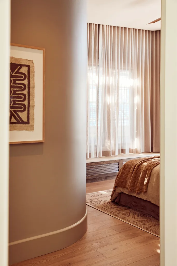 A neutral curved wall leading into a main bedroom.