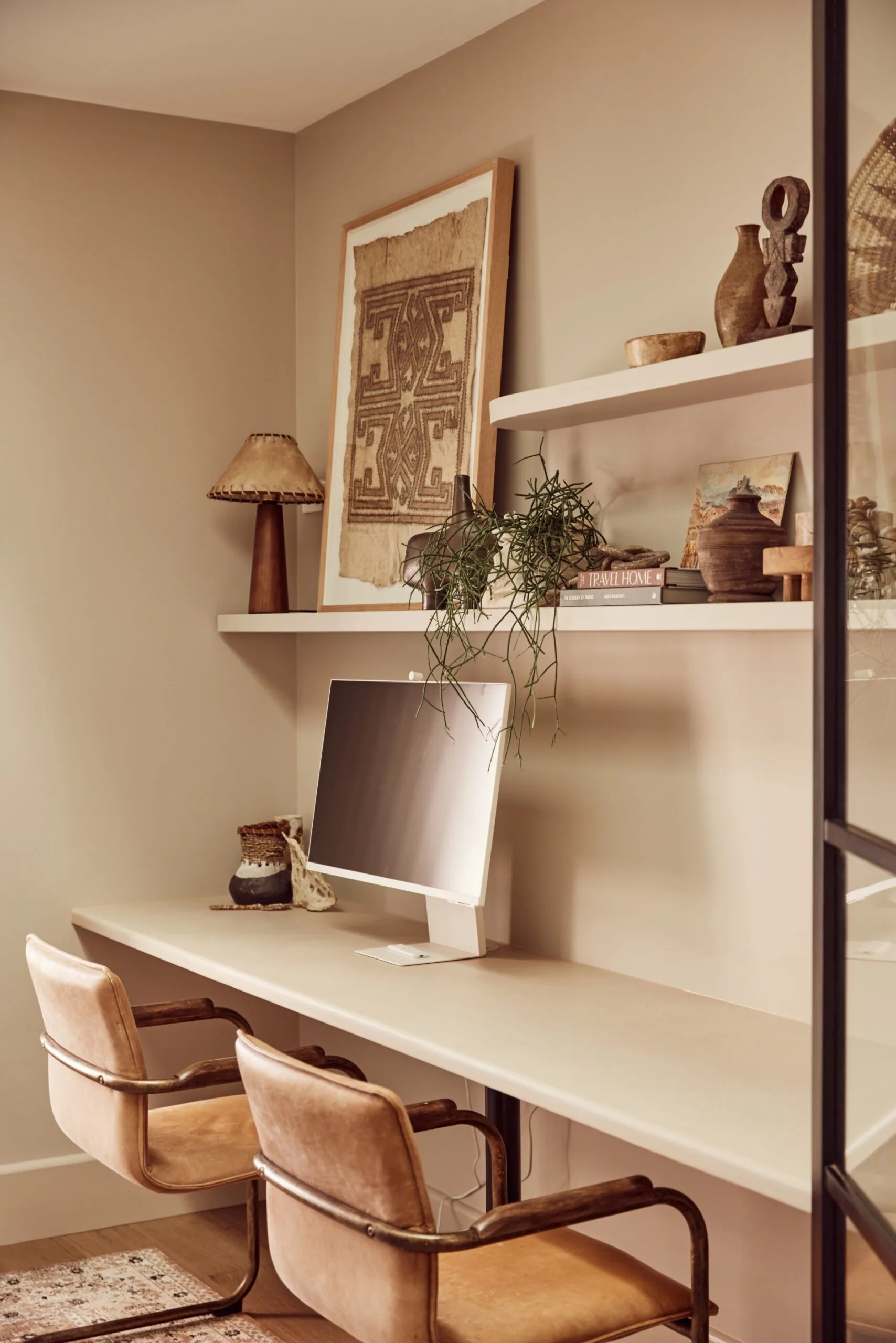 A home office with an in-built desk and natural shelf decor.