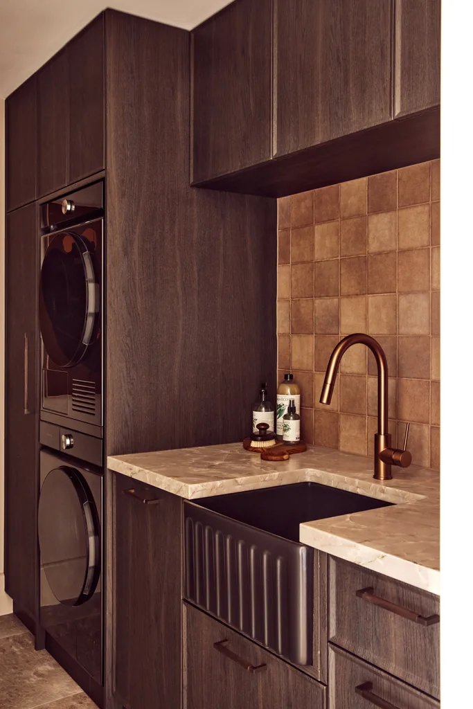 A laundry room with dark timber joinery.