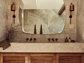 A main bathroom with rock salt tiles and a wooden floating vanity topped with stone.
