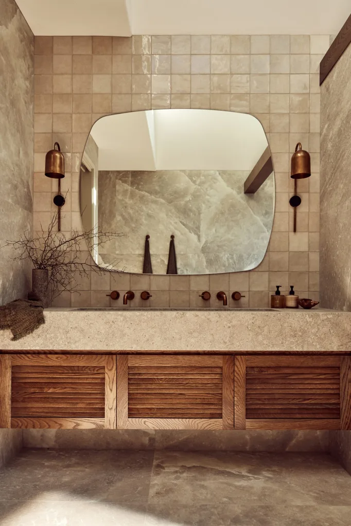 A main bathroom with rock salt tiles and a wooden floating vanity topped with stone.