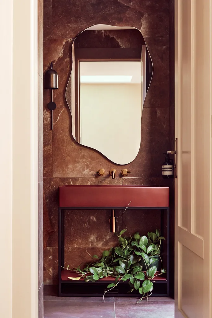 A Spanish resort style powder room with a curved mirror.