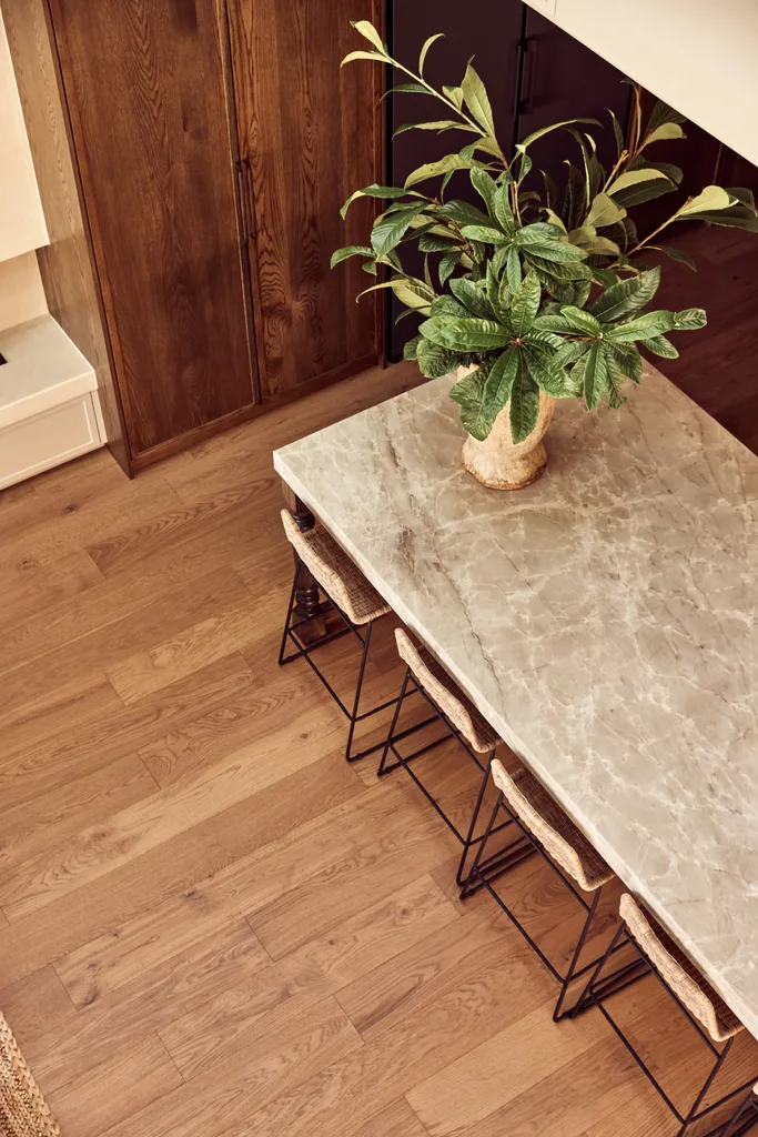 A natural stone dining table and timber flooring.