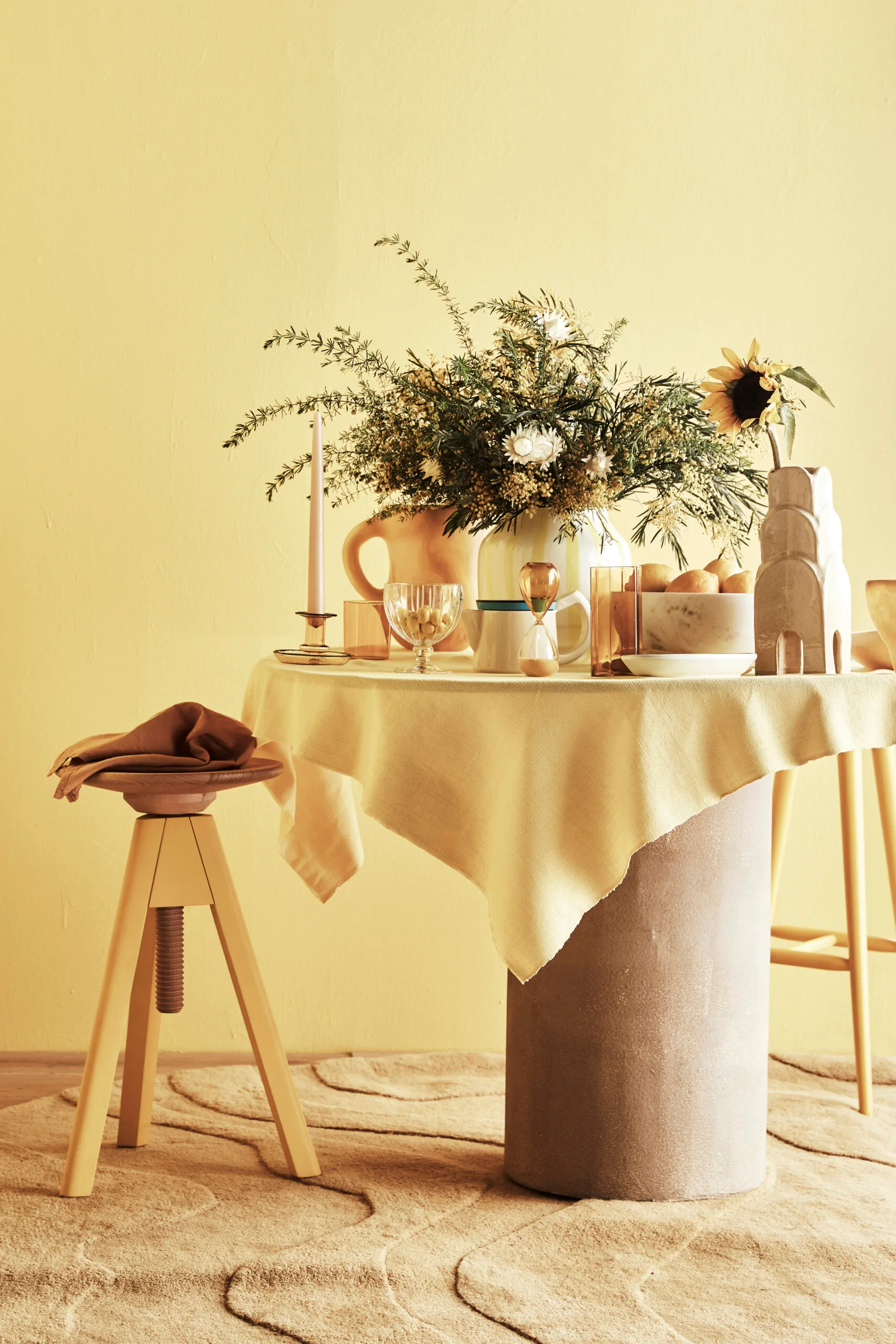 Butter yellow table setting with butter yellow tablecloth, rug and tablewares