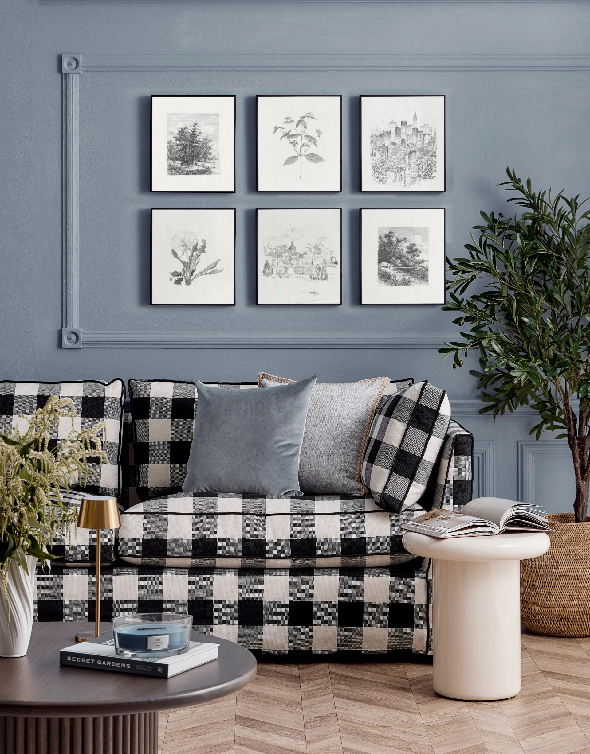 Black and white chequered couch in front of a blue wall with black and white artworks arranged in a grid pattern