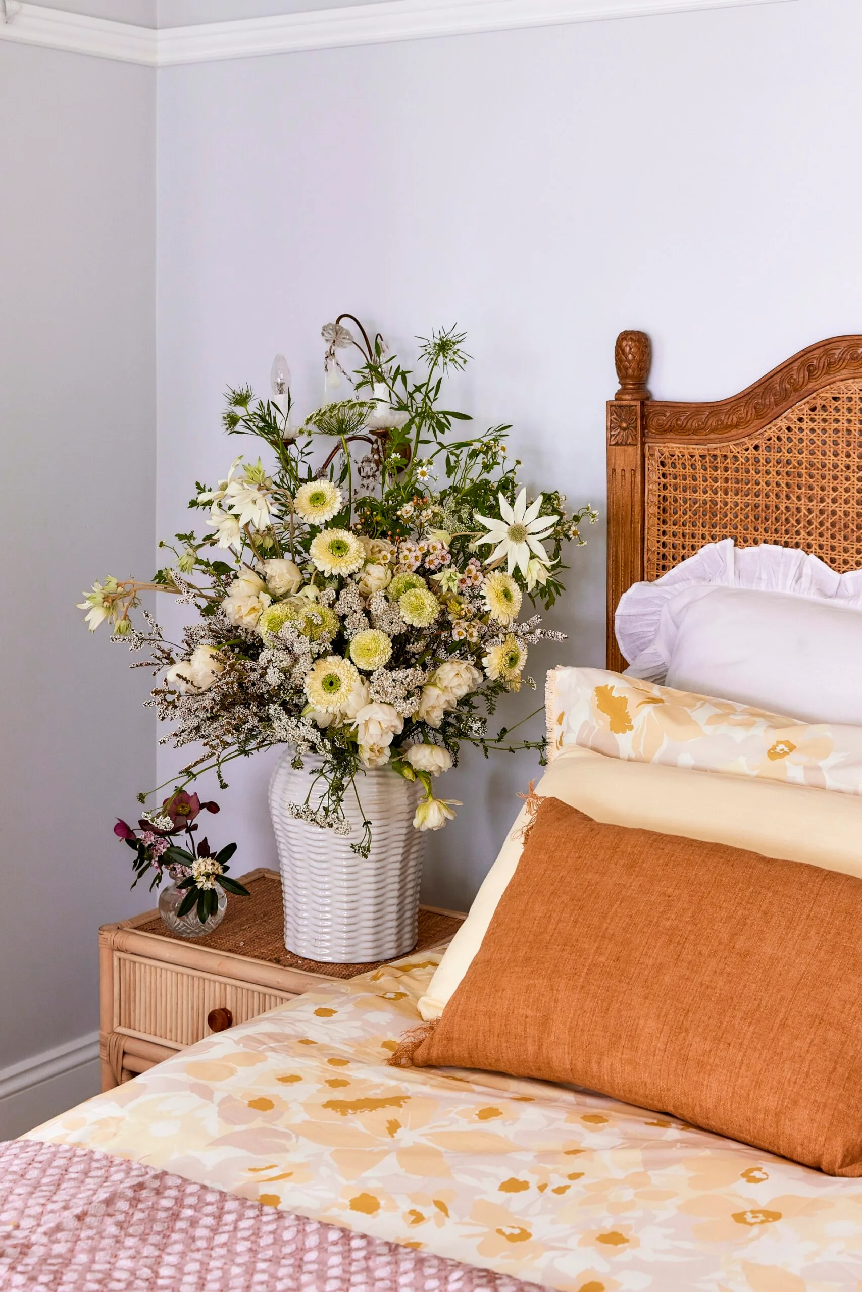 This bedroom is filled with woven items, from the rattan bedhead to the braided bedside table.