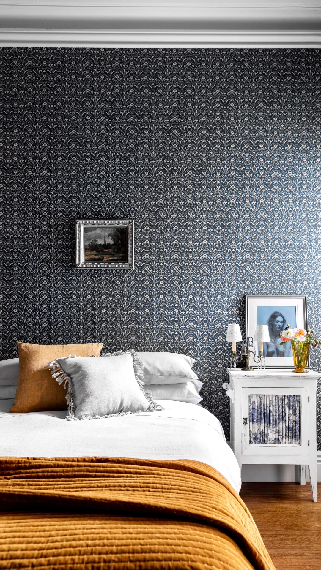 Shot of a bed with patterned wallpaper in the background