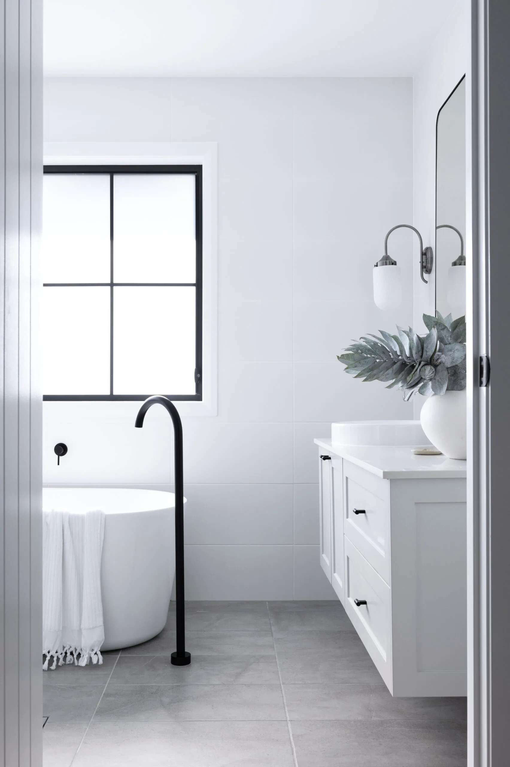 American barn style bathroom with a statement black window frame. 